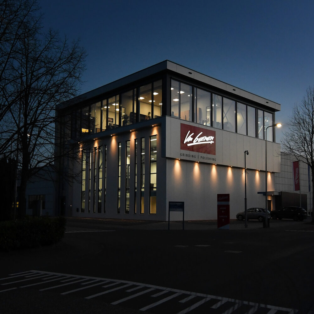 Het bedrijfspand van Van Geenen aan de Industrieweg in Rijssen, verlicht in de avond