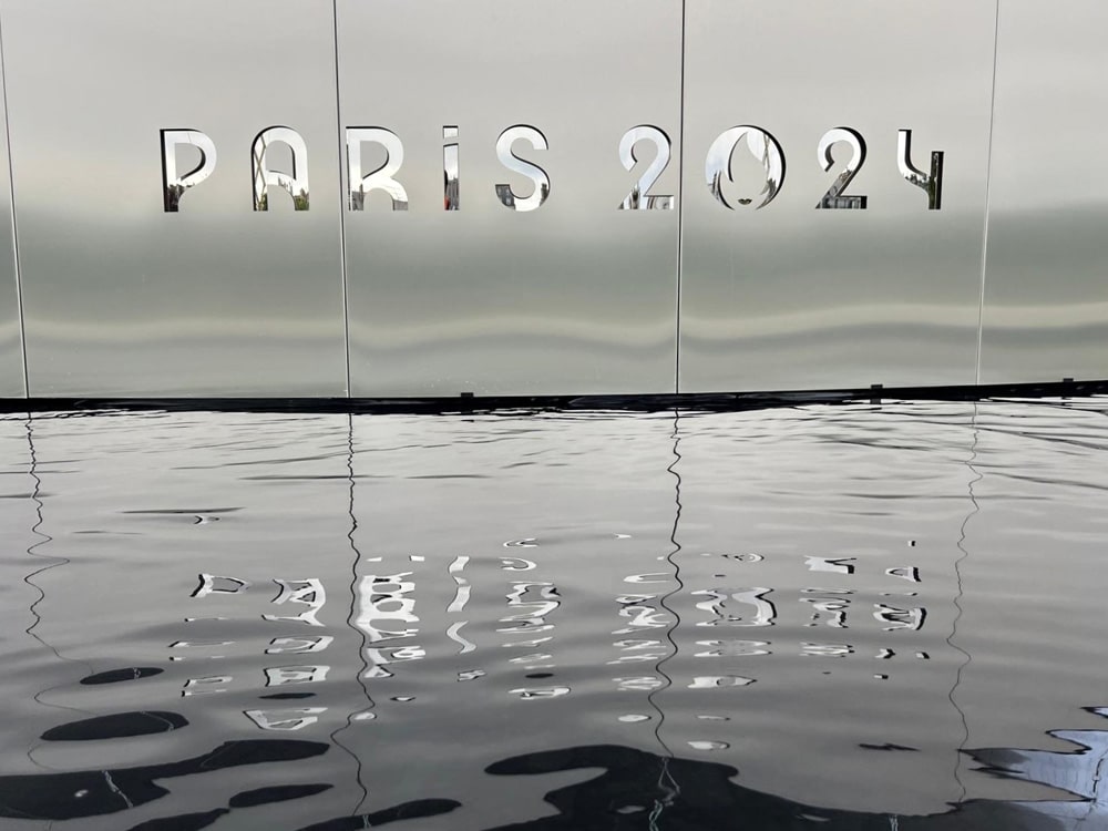 Champagnekleurige nanoINOX RVS-panelen in een kunstinstallatie, spiegelend oppervlak met watereflectie