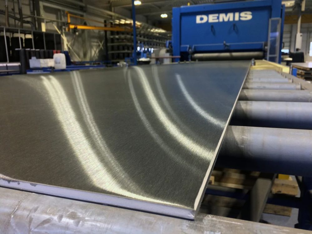 Geborsteld RVS plaat op de productielijn, slijpmachine op de achtergrond