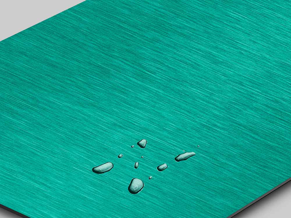 Groene nanoINOX RVS-plaat in Green Electrum-tint op Satin-afwerking, waterdruppels parelen af op het oppervlak