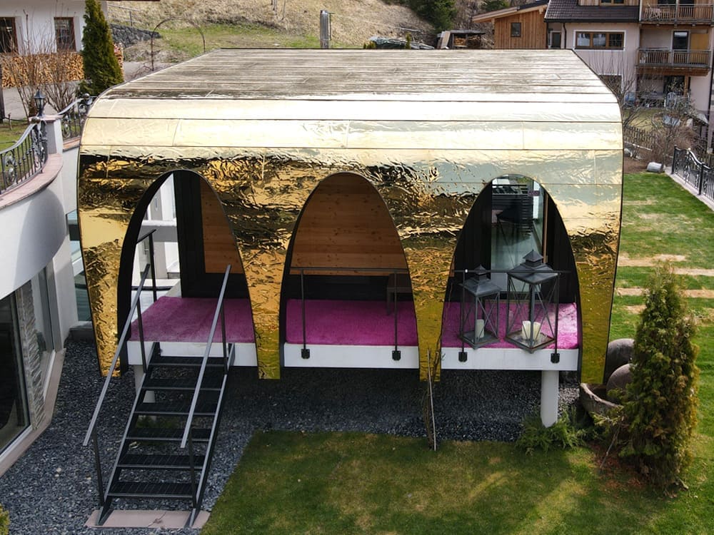 Gevelbekleding in Swell/Water Ripple RVS met gouden PVD Gold-TiN-afwerking, close-up van de gewelfde constructie met zichtbaar golfreliëf