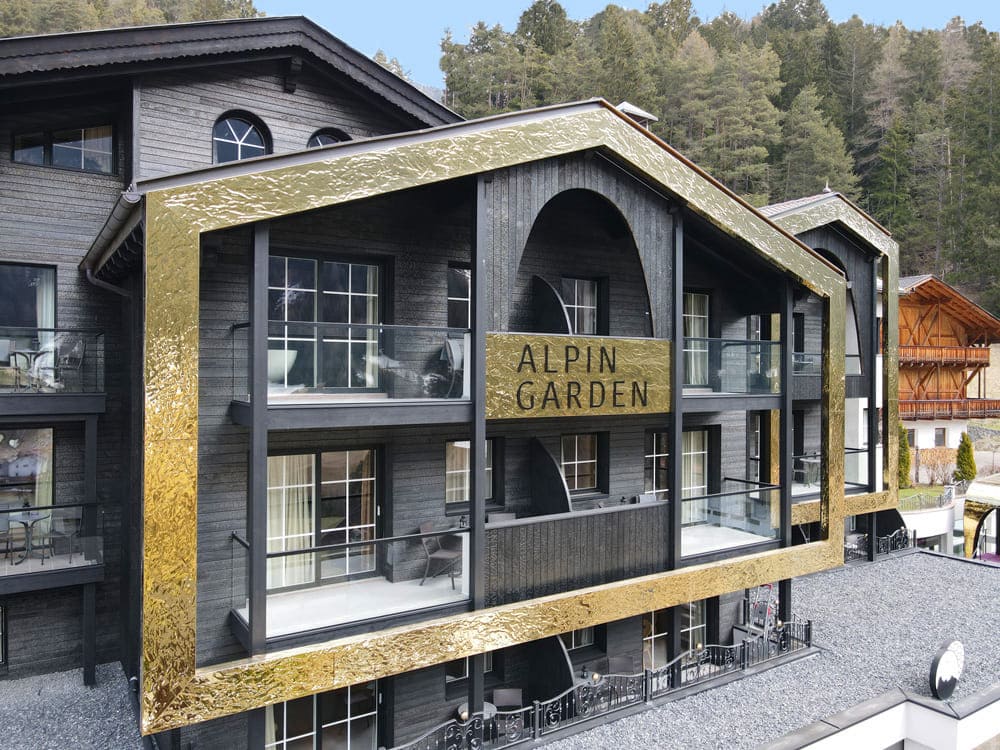Gevelbekleding in Swell/Water Ripple RVS met gouden PVD Gold-TiN-afwerking aan een alpine gebouw
